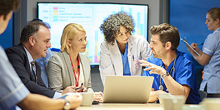 Group of healthcare workers gathered around a computer
